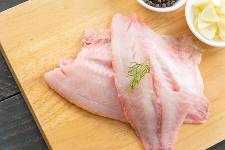 tilapia raw on wood board