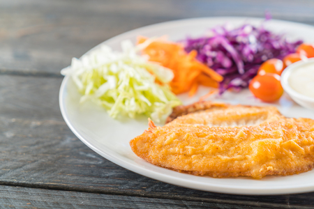 fried fish steak on wood backgroundの写真素材