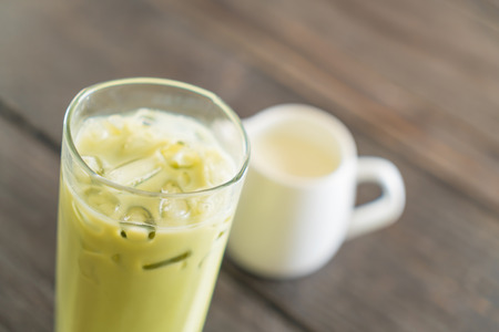 iced matcha latte on wood backgroundの写真素材