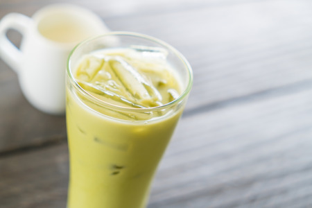 iced matcha latte on wood backgroundの写真素材