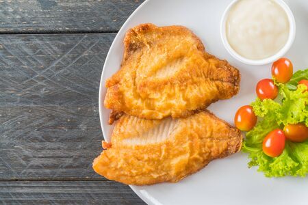 fried fish steak on wood background