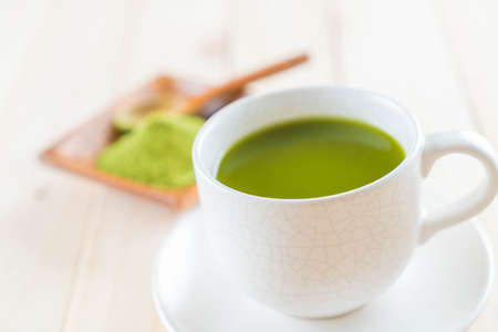 hot matcha on wood background - soft focus with vintage film filterの写真素材