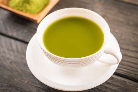 hot matcha on wood background - soft focus with vintage film filterの写真素材