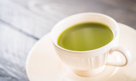 hot matcha on wood background - soft focus with vintage film filterの写真素材
