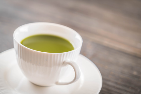 hot matcha on wood background - soft focus with vintage film filterの写真素材