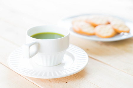 hot matcha on wood background - soft focus with vintage film filter