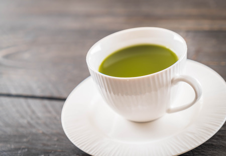 hot matcha on wood background - soft focus with vintage film filterの写真素材