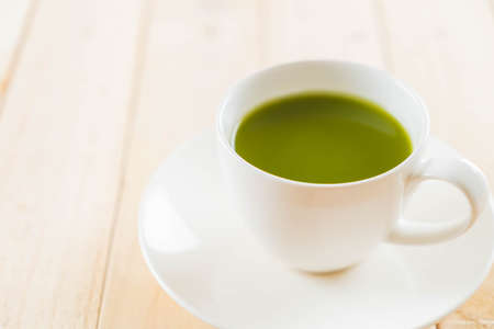 hot matcha on wood background - soft focus with vintage film filterの写真素材