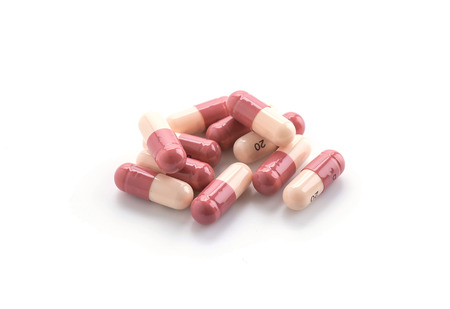 packings of pills and capsules of medicines on white background