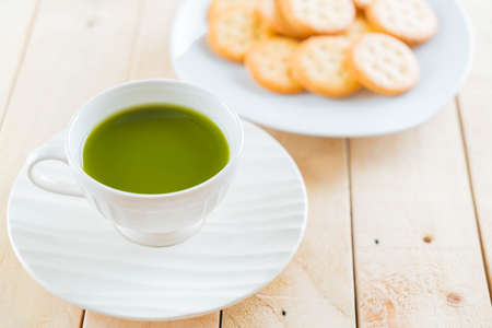 hot matcha on wood background - soft focus with vintage film filterの写真素材