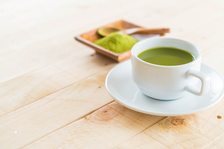 hot matcha on wood background - soft focus with vintage film filterの写真素材