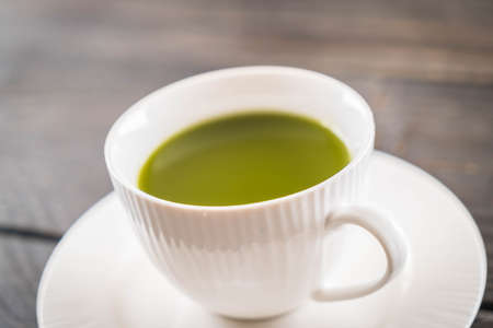 hot matcha on wood background - soft focus with vintage film filterの写真素材