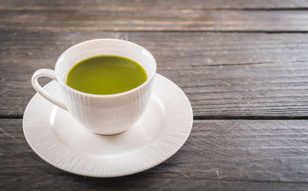 hot matcha on wood background - soft focus with vintage film filterの写真素材