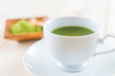 hot matcha on wood background - soft focus with vintage film filterの写真素材