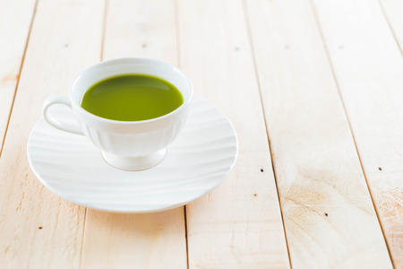 hot matcha on wood background - soft focus with vintage film filterの写真素材