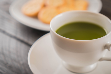 hot matcha on wood background - soft focus with vintage film filterの写真素材