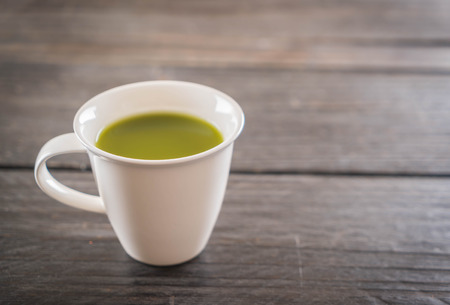 hot matcha on wood background - soft focus with vintage film filterの写真素材
