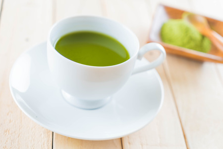 hot matcha on wood background - soft focus with vintage film filterの写真素材