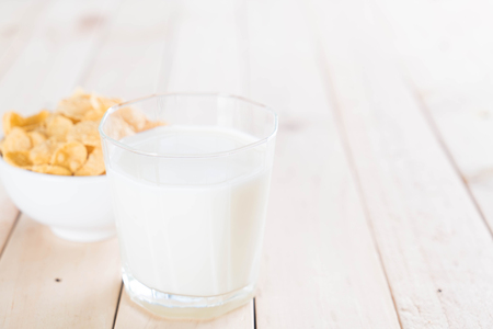 milk and cereal on wood tableの写真素材