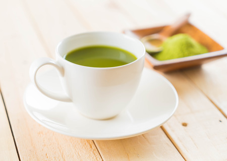 hot matcha on wood background - soft focus with vintage film filterの写真素材