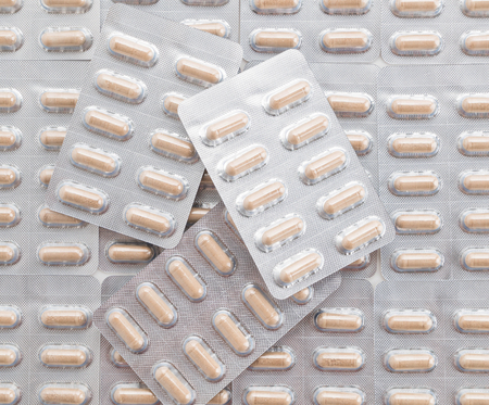 packings of pills and capsules of medicines on white backgroundの写真素材
