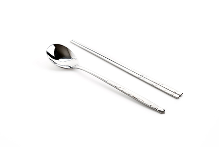 A set of Korean flat metal chopsticks and spoon on white backgroundの写真素材