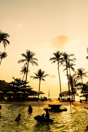 Beautiful luxury swimming pool in hotel resort with silhouette umbrella and chair around pool with sunset and twilight times - Vintage Filter and Boost up color Processingの写真素材