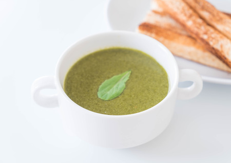 Spinach soup with spinach leaves and breadの写真素材