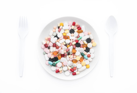 Colorful capsules and pills on plateの写真素材