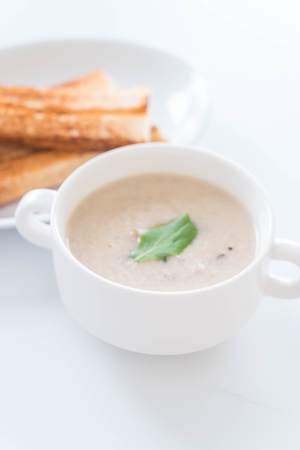 mushroom soup and bread in white ceramic cupの写真素材