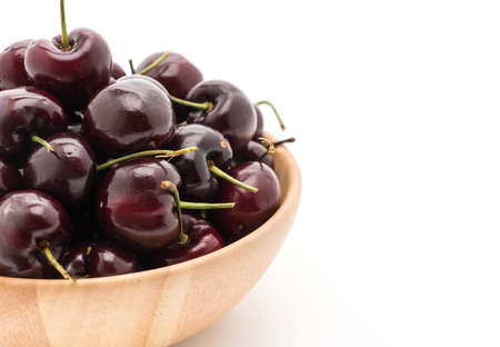 fresh cherry on wood plate on whiteの写真素材