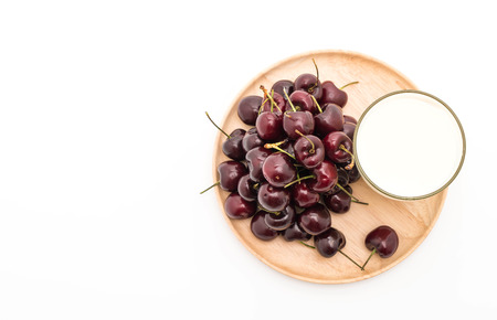 fresh cherry with milk on wood plate on whiteの写真素材