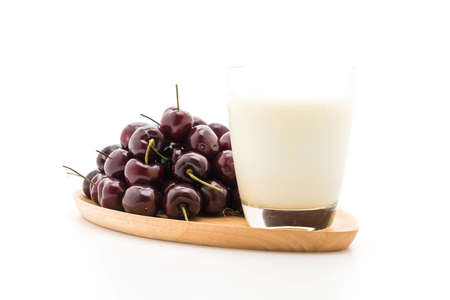 fresh cherry with milk on wood plate on whiteの写真素材