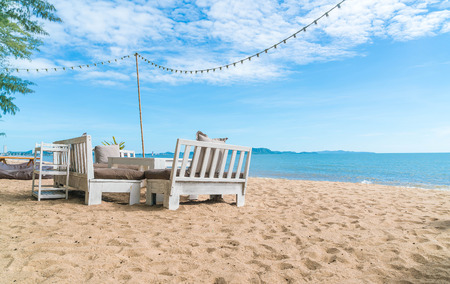white chairs and table on beach with a view of blue ocean and clear sky