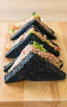 tuna charcoal  sandwich on wood tableの写真素材