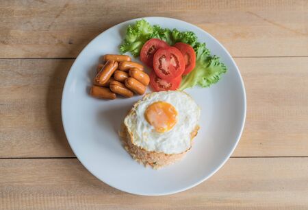 fried rice with sausage and fried egg on the tableの写真素材