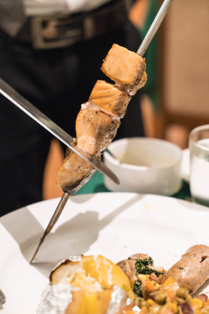 slicing steak brazillian style on plateの写真素材