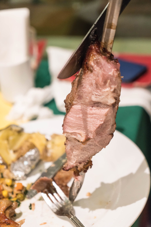 slicing steak brazillian style on plateの写真素材