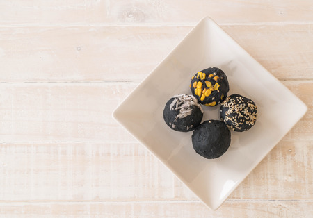 Charcoal potato ball on white plateの写真素材