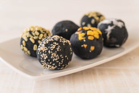 Charcoal potato ball on white plateの写真素材