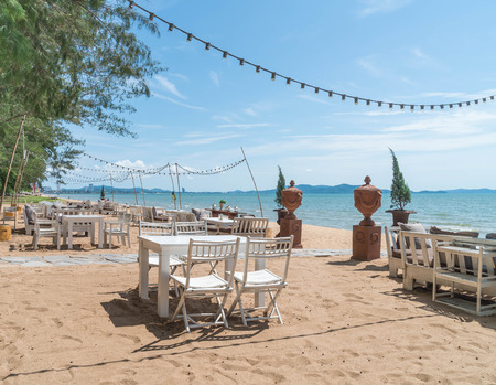 white chairs and table on beach with a view of blue ocean and clear sky - boost up colour and lighting processing styleの写真素材