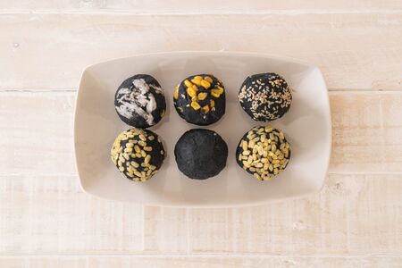 Charcoal potato ball on white plateの写真素材