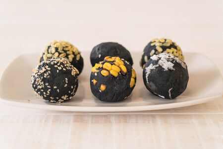 Charcoal potato ball on white plateの写真素材