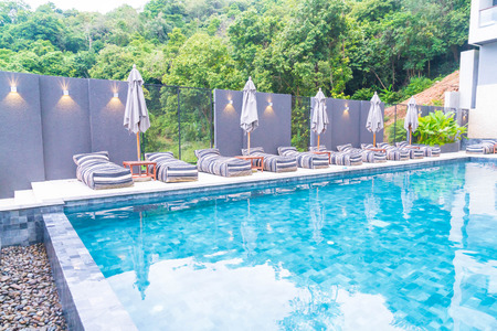 Beautiful luxury umbrella and chair around outdoor swimming pool in hotel and resortのeditorial素材