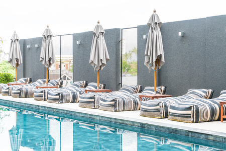 Beautiful luxury umbrella and chair around outdoor swimming pool in hotel and resortの写真素材