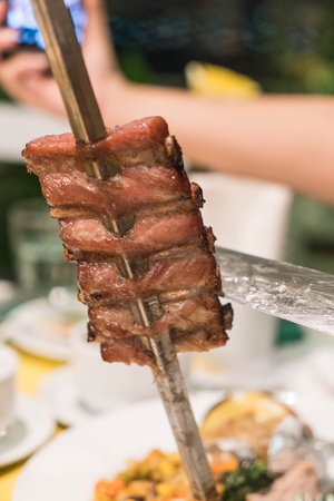 slicing steak brazillian style on plateの写真素材