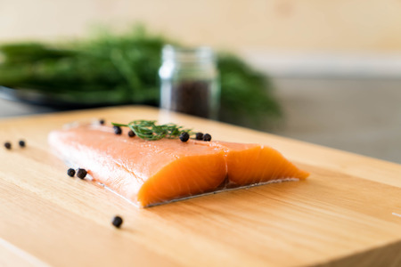 Fresh Salmon Fillet on board  with black peppersの写真素材
