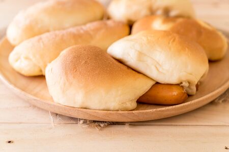 bread in wood plate on the tableの写真素材