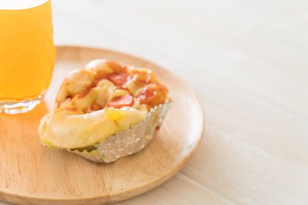 sausage mayonnaise bread with orange juice on wood plateの写真素材