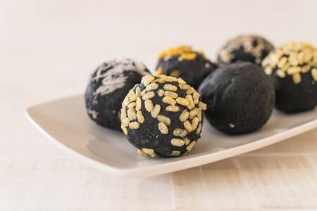 Charcoal potato ball on white plateの写真素材